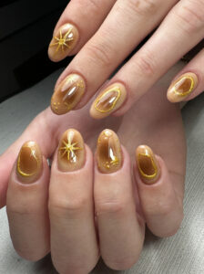 Uñas en tono ámbar con decoración dorada