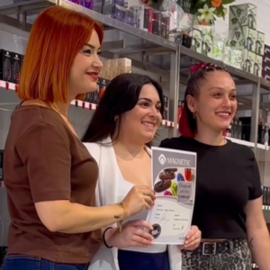 Dos alumnas mostrando su diploma junto a una formadora